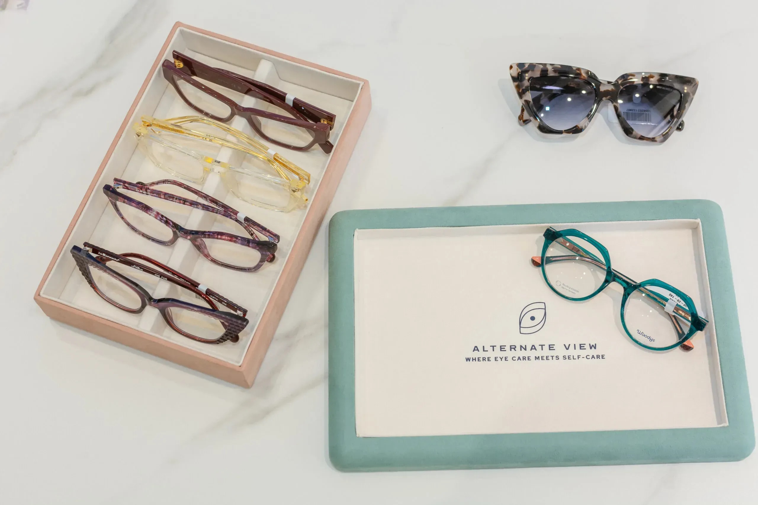Eyewear collection in branded storage boxes and on display with sunglasses