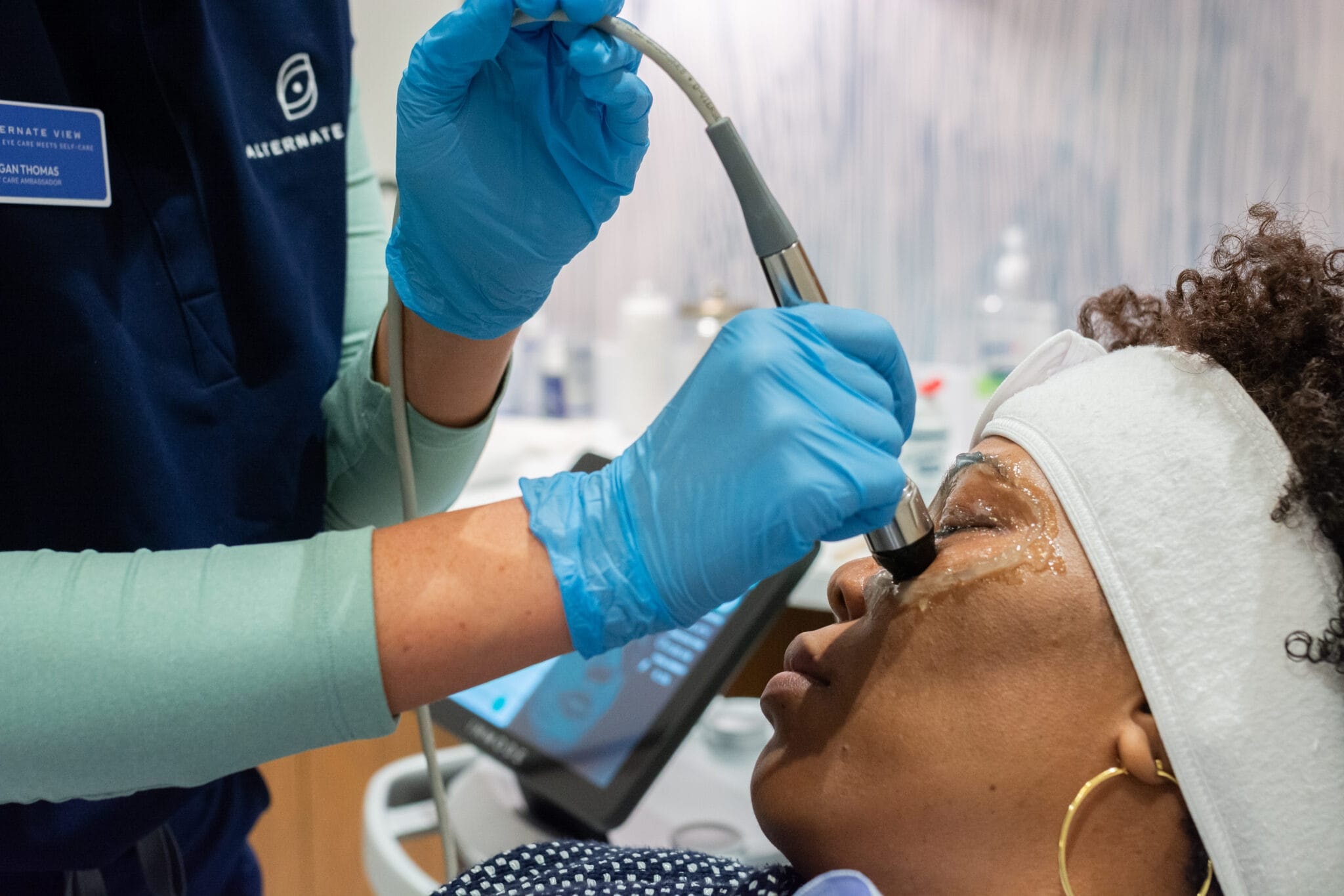 Aesthetic nurse practitioner applies RF microneedling device to patient's face during treatment consultation