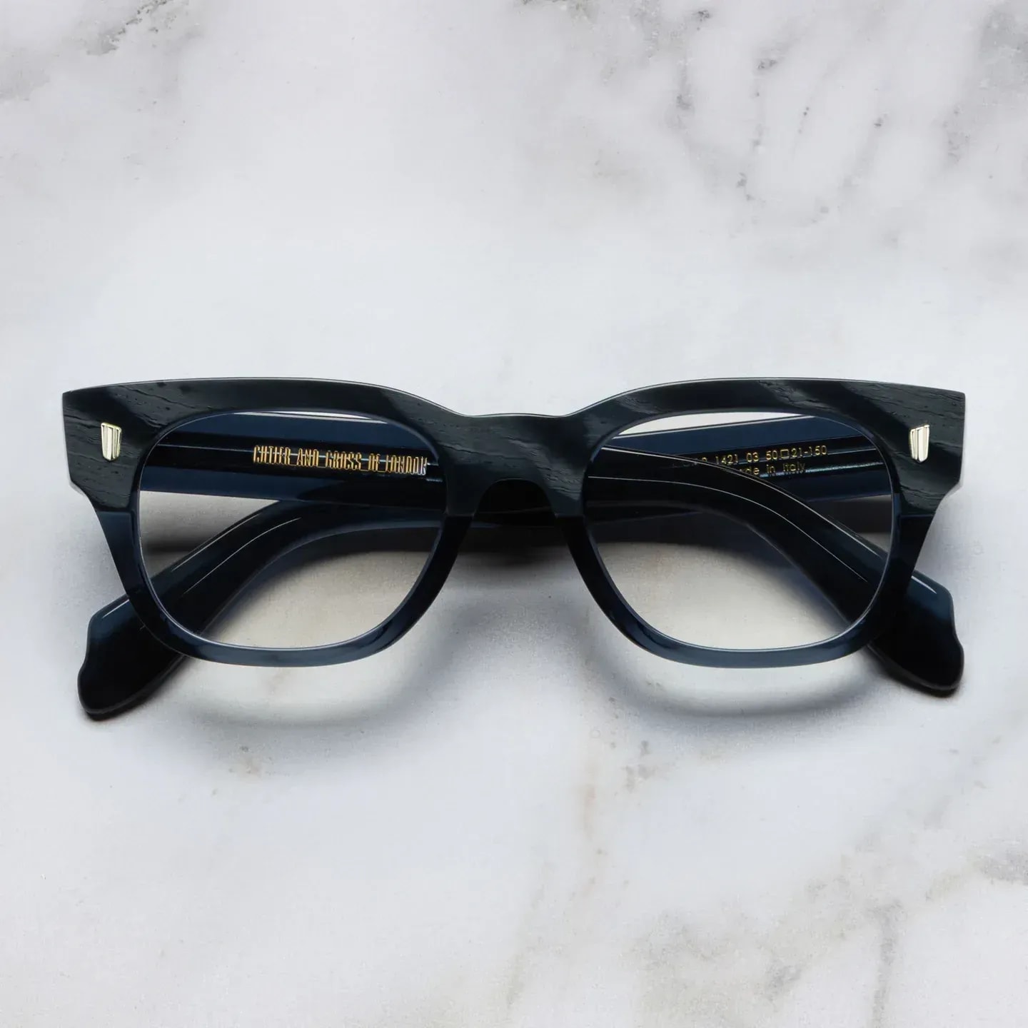 Black acetate eyeglasses with clear lenses on marble background